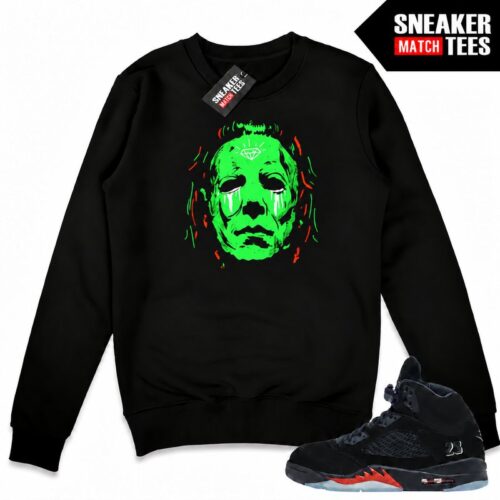 Black Halloween 5s crewneck sweatshirt with a green-glow Michael Myers front graphic, orange accents, and matching Air Jordan 5 sneakers